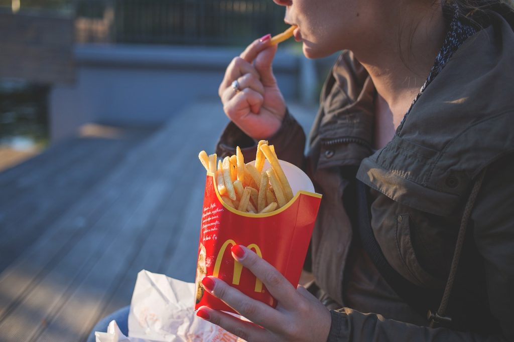 Una noia menjant patates del McDonald's